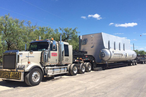 A Parish Transport removable gooseneck flatbed trailer hauls an oversize load