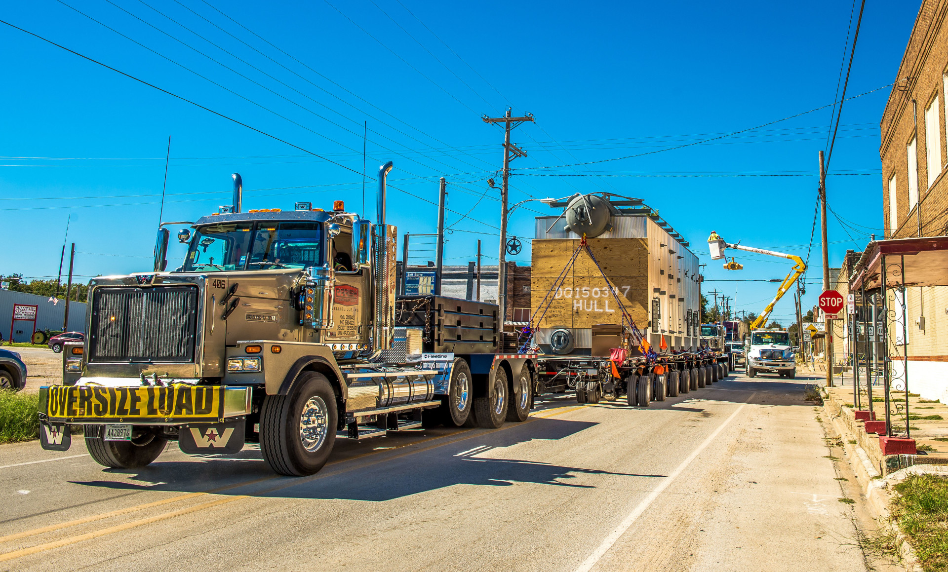 A Parish Transport hydraulic platform flatbed trailer hauls an oversize load down a main road